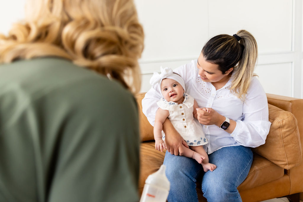 Ally Gore talking with a caregiver holding an infant