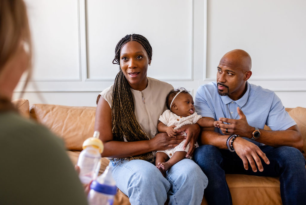 Parents holding their infant during a feeding conversation with a clinician