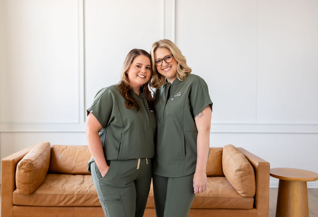 Co-founders Brittany Shockley and Ally Gore standing together in green scrubs