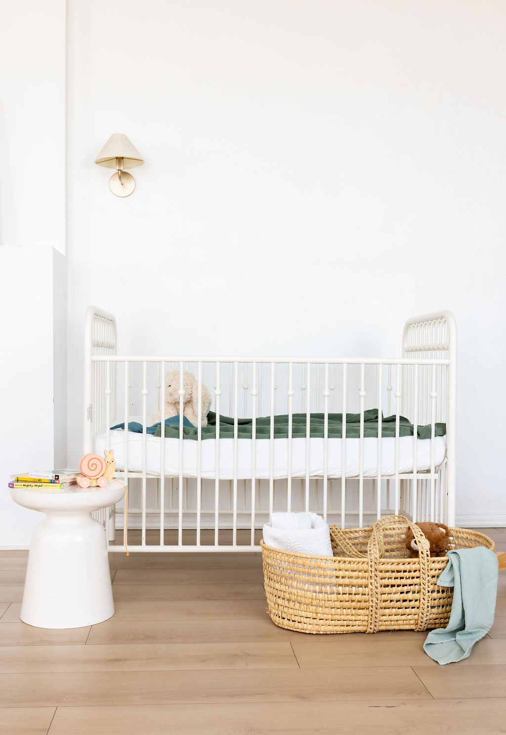 A styled nursery with a white crib, baskets, and toys